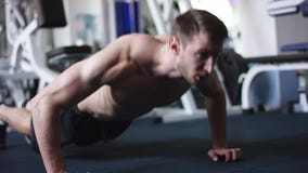 Hübscher junger Mann, den das Handeln drückt, ups in eine Turnhalle stock video Hübscher junger Mann, den das Handeln drückt, ups in eine Turnhalle stock video