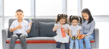 I bambini asiatici che si siedono e tenere imbottiglia le mani immagini stock libere da diritti I bambini asiatici che si siedono e tenere imbottiglia le mani immagini stock libere da diritti