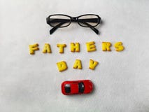 I biscotti delle lettere, i vetri e l'automobile rossa del giocattolo sono sistemati su un fondo bianco immagine stock I biscotti delle lettere, i vetri e l'automobile rossa del giocattolo sono sistemati su un fondo bianco immagine stock