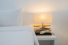 I cuscini su stile della lampada del lusso e del letto dal lato di legno della tavola in camera da letto progettano, stile tratta immagine stock I cuscini su stile della lampada del lusso e del letto dal lato di legno della tavola in camera da letto progettano, stile tratta immagine stock