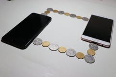 I due telefoni cellulari sono collegati da un cavo composti delle monete fotografie stock libere da diritti I due telefoni cellulari sono collegati da un cavo composti delle monete fotografie stock libere da diritti