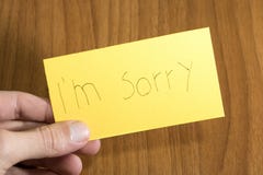 I handwrite triste del ` m en un papel amarillo con una pluma en una tabla fotografía de archivo libre de regalías I handwrite triste del ` m en un papel amarillo con una pluma en una tabla fotografía de archivo libre de regalías