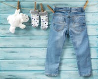 I jeans del neonato, i calzini ed il giocattolo bianco riguardano una corda da bucato fotografia stock libera da diritti I jeans del neonato, i calzini ed il giocattolo bianco riguardano una corda da bucato fotografia stock libera da diritti