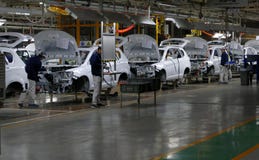 I lavoratori montano un'automobile sulla catena di montaggio nella fabbrica dell'automobile immagini stock libere da diritti I lavoratori montano un'automobile sulla catena di montaggio nella fabbrica dell'automobile immagini stock libere da diritti