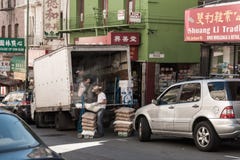 I lavoratori scaricano le merci da un camion in Chinatown a San Francisco, la California, U.S.A. immagine stock I lavoratori scaricano le merci da un camion in Chinatown a San Francisco, la California, U.S.A. immagine stock