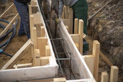 I lavoratori versano concreto nel fondamento fotografia stock libera da diritti I lavoratori versano concreto nel fondamento fotografia stock libera da diritti