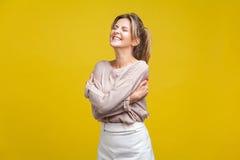 I love myself. Portrait of proud beautiful woman with fair hair in casual beige blouse, isolated on yellow background