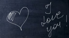 I love you. Handwritten chalk on a black chalkboard. Arrow shot heart shape. Love at school concept.