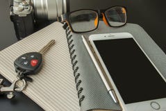I taccuini, telefoni cellulari, vetri, macchine fotografiche, chiavi dell'automobile hanno disposto sulla tavola fotografia stock I taccuini, telefoni cellulari, vetri, macchine fotografiche, chiavi dell'automobile hanno disposto sulla tavola fotografia stock