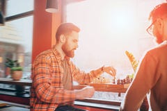 I tipi seri e concentrati stanno giocando il petto alla tavola Ora tempo del ` s di fare un punto per un tipo a sinistra mentre Immagini Stock I tipi seri e concentrati stanno giocando il petto alla tavola Ora tempo del ` s di fare un punto per un tipo a sinistra mentre Immagini Stock