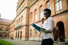 Ich bestehe diese Prüfung Glückliche Weile des jungen afroen-amerikanisch Studentenblickes las Anmerkungen von den Lehrbüchern, e lizenzfreie stockbilder Ich bestehe diese Prüfung Glückliche Weile des jungen afroen-amerikanisch Studentenblickes las Anmerkungen von den Lehrbüchern, e lizenzfreie stockbilder