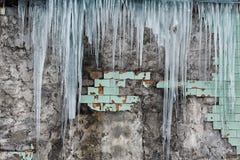 Icicles hanging from the roof of the old brick building with cubes of old tiles, traumatic acrid ice, thaw in the early spring, se Stock Photography Icicles hanging from the roof of the old brick building with cubes of old tiles, traumatic acrid ice, thaw in the early spring, se Stock Photography