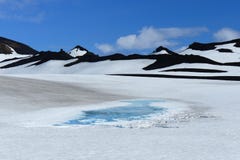 Icy blue lake in the middle of a black rock and white snow landscape on Fimmvörduhals mountain pass, Iceland royalty free stock photo Icy blue lake in the middle of a black rock and white snow landscape on Fimmvörduhals mountain pass, Iceland royalty free stock photo