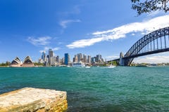 Ideia larga impressionante da skyline da cidade do ângulo da área do porto de Sydney CBD no cais circular com a ópera e a ponte d Imagem de Stock Royalty Free Ideia larga impressionante da skyline da cidade do ângulo da área do porto de Sydney CBD no cais circular com a ópera e a ponte d Imagem de Stock Royalty Free