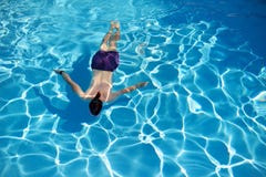 Ideia superior de uma natação do homem em uma piscina no dia de verão ensolarado Imagens de Stock Ideia superior de uma natação do homem em uma piscina no dia de verão ensolarado Imagens de Stock