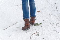 Ideia traseira dos pés fêmeas nas botas que andam no trajeto do inverno através da neve Foto de Stock Ideia traseira dos pés fêmeas nas botas que andam no trajeto do inverno através da neve Foto de Stock