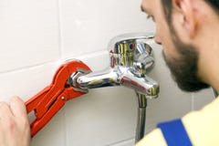 Idraulico che installa il rubinetto di acqua nel bagno fotografie stock Idraulico che installa il rubinetto di acqua nel bagno fotografie stock