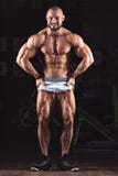 Idrotts- man för stark kroppsbyggare som upp pumpar bakgrund för begrepp för muskelgenomkörarebodybuilding royaltyfri foto Idrotts- man för stark kroppsbyggare som upp pumpar bakgrund för begrepp för muskelgenomkörarebodybuilding royaltyfri foto