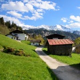 Idylliczny krajobraz w Alps z świeżymi zielonymi łąkami, kwitnienie kwiatami i snowcapped halnymi wierzchołkami w zdjęcie royalty free Idylliczny krajobraz w Alps z świeżymi zielonymi łąkami, kwitnienie kwiatami i snowcapped halnymi wierzchołkami w zdjęcie royalty free