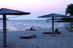 Iew de plage sablonneuse avec les parapluies et les lits en bambou du soleil au lever de soleil photos stock Iew de plage sablonneuse avec les parapluies et les lits en bambou du soleil au lever de soleil photos stock