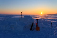 Igloo non fini au coucher du soleil Dans la neige les blocs ont collé des outils pour établir une maison photo stock Igloo non fini au coucher du soleil Dans la neige les blocs ont collé des outils pour établir une maison photo stock