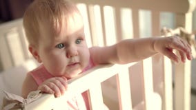 Il bambino adorabile raggiunge fuori la mano in culla Piccolo bambino con il fronte interessante archivi video Il bambino adorabile raggiunge fuori la mano in culla Piccolo bambino con il fronte interessante archivi video