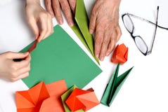 Il bambino e la nonna fanno gli origami immagini stock libere da diritti Il bambino e la nonna fanno gli origami immagini stock libere da diritti