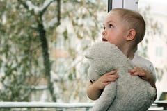 Il bambino vicino alla finestra immagine stock libera da diritti Il bambino vicino alla finestra immagine stock libera da diritti
