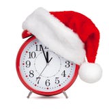 Il cappello Santa Claus ha messo sopra una sveglia Fotografia Stock Il cappello Santa Claus ha messo sopra una sveglia Fotografia Stock