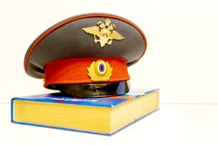Il cappuccio di un ufficiale di polizia russo ? sul codice delle leggi isolato immagine stock libera da diritti Il cappuccio di un ufficiale di polizia russo ? sul codice delle leggi isolato immagine stock libera da diritti