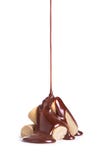 Il cioccolato fuso è versato su una pila di dolci del caramello del latte Immagine Stock Libera da Diritti Il cioccolato fuso è versato su una pila di dolci del caramello del latte Immagine Stock Libera da Diritti