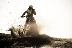 Il corridore di motocross roosts la banchina della sporcizia sulla pista. fotografia stock libera da diritti Il corridore di motocross roosts la banchina della sporcizia sulla pista. fotografia stock libera da diritti