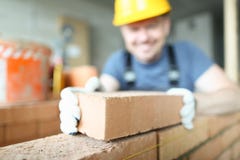Il costruttore sorridente maschio mette per fare la muratura immagini stock libere da diritti Il costruttore sorridente maschio mette per fare la muratura immagini stock libere da diritti