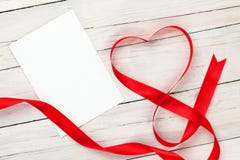 Il cuore del giorno di biglietti di S. Valentino ha modellato il nastro rosso e la cartolina d'auguri in bianco immagine stock libera da diritti Il cuore del giorno di biglietti di S. Valentino ha modellato il nastro rosso e la cartolina d'auguri in bianco immagine stock libera da diritti