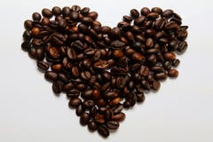 Il cuore ha modellato i chicchi di caffè isolati sulla terra della parte posteriore di bianco fotografia stock libera da diritti Il cuore ha modellato i chicchi di caffè isolati sulla terra della parte posteriore di bianco fotografia stock libera da diritti