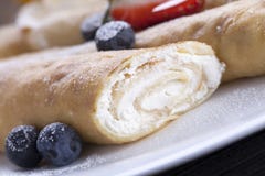 Il dolce delizioso ha rotolato i pancake su un piatto con la frutta fresca immagini stock Il dolce delizioso ha rotolato i pancake su un piatto con la frutta fresca immagini stock