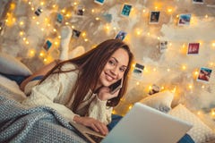 Il fine settimana della giovane donna a casa ha decorato la camera da letto che parla dallo smartphone immagini stock libere da diritti Il fine settimana della giovane donna a casa ha decorato la camera da letto che parla dallo smartphone immagini stock libere da diritti