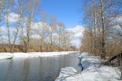 Il fiume sveglia in primavera Il ghiaccio si è fuso, ma i blocchi enormi di neve ancora appendono sopra le banche e sopra l'acqua fotografia stock libera da diritti Il fiume sveglia in primavera Il ghiaccio si è fuso, ma i blocchi enormi di neve ancora appendono sopra le banche e sopra l'acqua fotografia stock libera da diritti