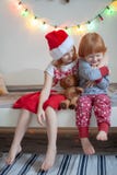 Il fratello e la sorella si siedono su un letto fotografia stock Il fratello e la sorella si siedono su un letto fotografia stock