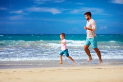 Il funzionamento emozionante felice del figlio e del padre sull'estate tira, gode della vita in secco fotografia stock libera da diritti Il funzionamento emozionante felice del figlio e del padre sull'estate tira, gode della vita in secco fotografia stock libera da diritti