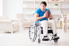 Il giocatore di football americano del giovane che recupera sulla sedia a rotelle Immagine Stock Il giocatore di football americano del giovane che recupera sulla sedia a rotelle Immagine Stock