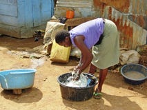 Il giovane lavaggio africano della donna copre l'Uganda urbano fotografia stock Il giovane lavaggio africano della donna copre l'Uganda urbano fotografia stock
