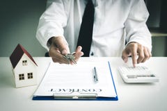 Il giovane si è accinto a per approvare i soldi per affittare una casa e un'automobile fotografia stock Il giovane si è accinto a per approvare i soldi per affittare una casa e un'automobile fotografia stock
