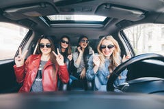 Il gruppo di divertiresi degli amici tenta l'azionamento l'automobile Cantando e ridere sulla strada fotografie stock Il gruppo di divertiresi degli amici tenta l'azionamento l'automobile Cantando e ridere sulla strada fotografie stock