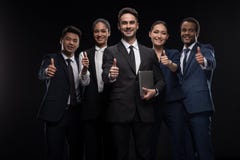 Il gruppo di gente di affari sorridente che sta e che gesturing sfoglia sul segno Fotografia Stock Il gruppo di gente di affari sorridente che sta e che gesturing sfoglia sul segno Fotografia Stock