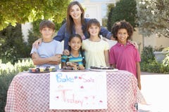 Il gruppo di tenuta dei bambini cuoce la vendita con la madre immagini stock Il gruppo di tenuta dei bambini cuoce la vendita con la madre immagini stock