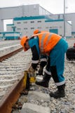 Il lavoratore stabilisce la presa per la ferrovia di sollevamento fotografia stock Il lavoratore stabilisce la presa per la ferrovia di sollevamento fotografia stock