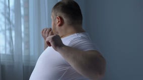 Il maschio obeso che fa gli esercizi posteriori che si siedono il letto, mancanza di sport, allungante muscles archivi video Il maschio obeso che fa gli esercizi posteriori che si siedono il letto, mancanza di sport, allungante muscles archivi video