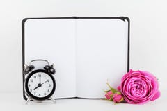 Il modello del fiore rosa decorato taccuino e la sveglia su fondo bianco con spazio pulito per testo e progettano il vostro blogg fotografia stock libera da diritti Il modello del fiore rosa decorato taccuino e la sveglia su fondo bianco con spazio pulito per testo e progettano il vostro blogg fotografia stock libera da diritti
