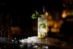 Il mojito alcolico del cocktail sta su un contatore della barra immagini stock libere da diritti Il mojito alcolico del cocktail sta su un contatore della barra immagini stock libere da diritti